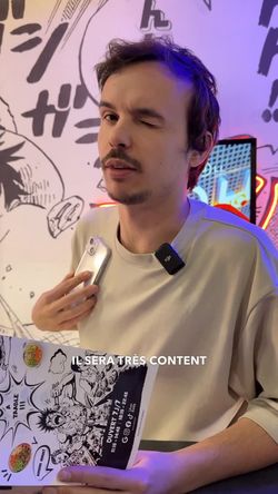 Intérieur du restaurant ROLLROLL Sèvres avec un jeune homme tenant un menu des spécialités japonaises et asiatiques.