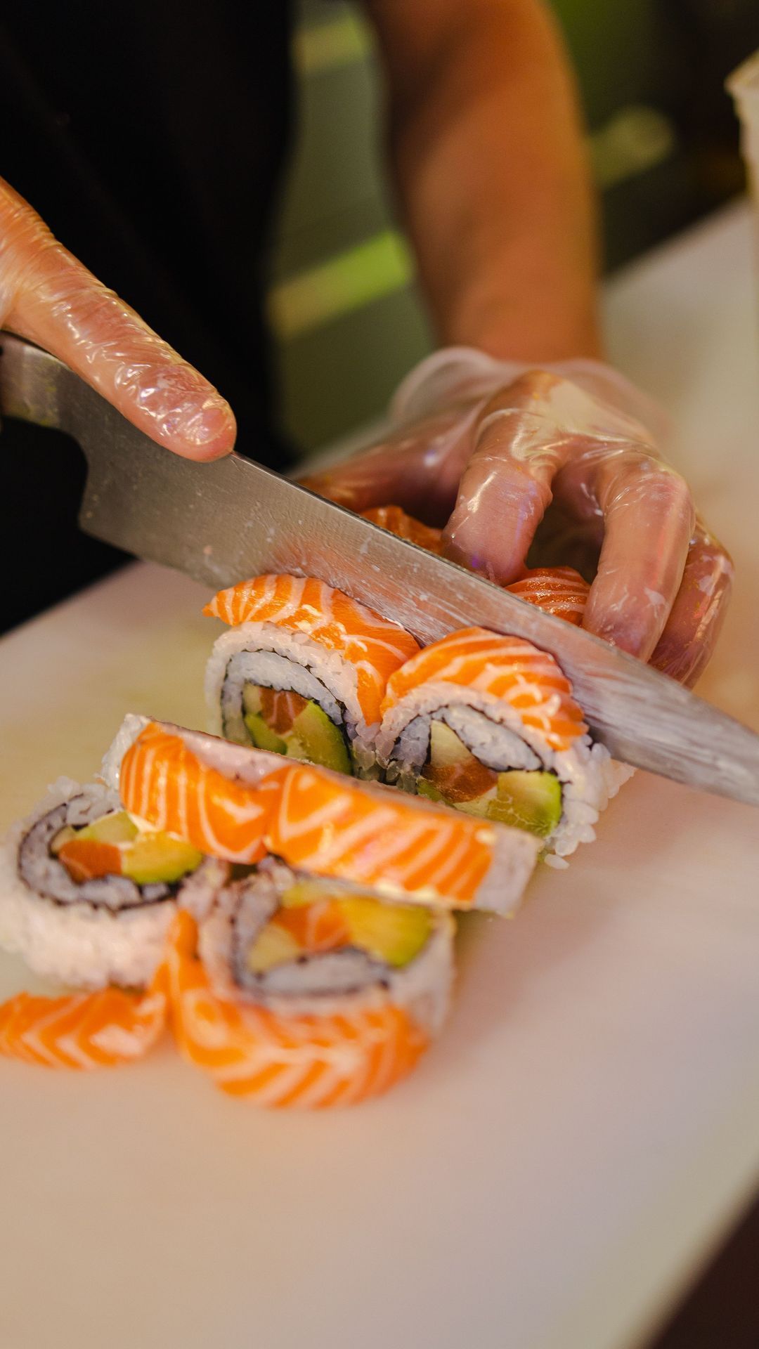 Préparation de sushis avec des tranches de saumon frais sur un plan de travail.