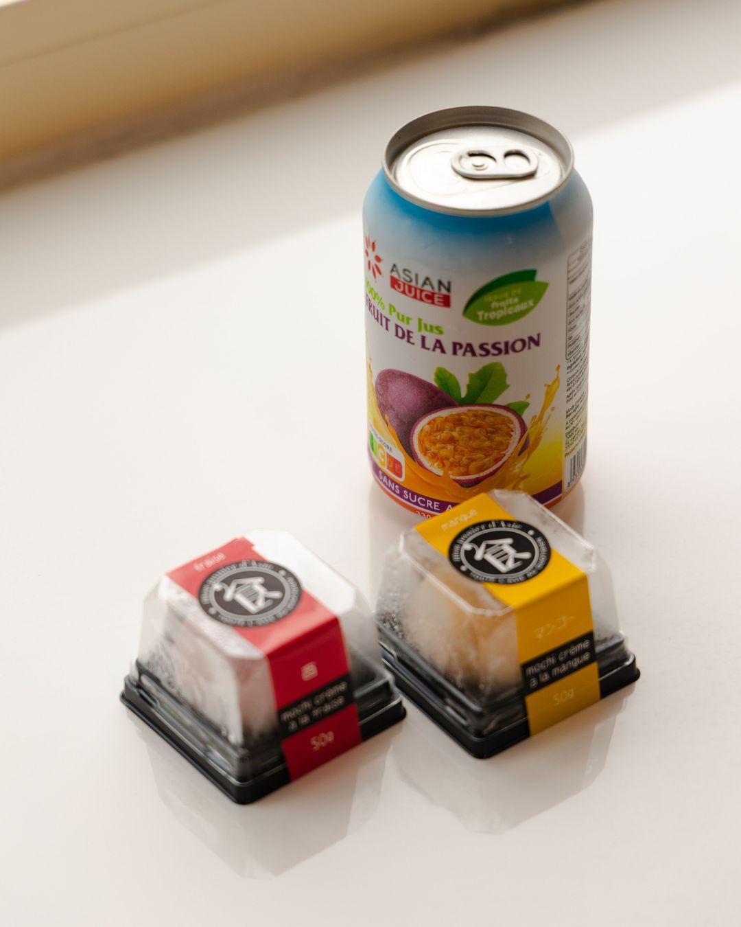 Bocaux de desserts japonais avec une boisson au fruit de la passion, posés sur une surface claire.